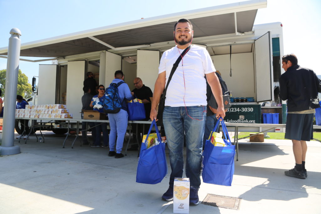 College student with groceries in front of Mobile Food Pantry