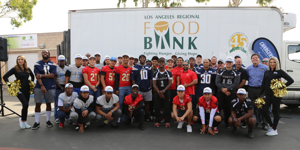LA Chargers and Michael Flood in front of a Los Angeles Regional Food Bank truck