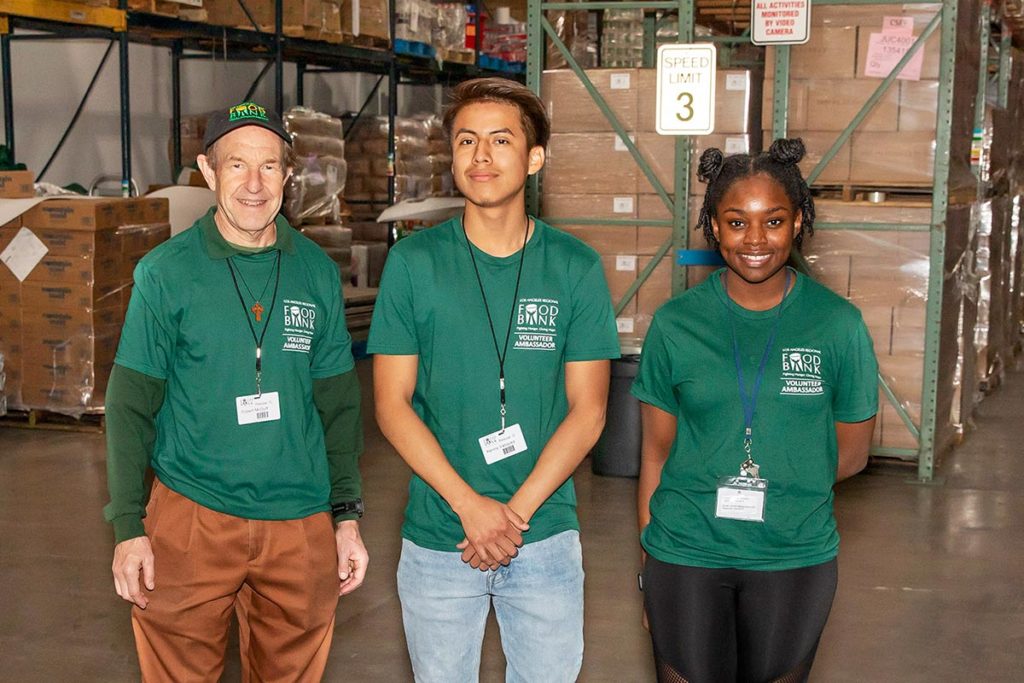 three people standing in warehouse smiling