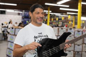 Robert Trujillo holding signed Metallica guitar