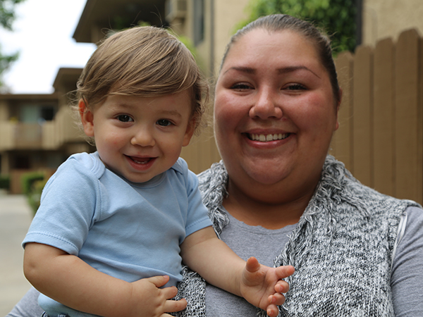 Amy and her youngest child of three, smiling.