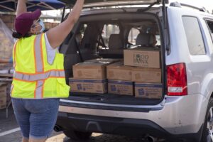 A volunteer loads up a car at a free food distribution with the Los Angeles Regional Food Bank