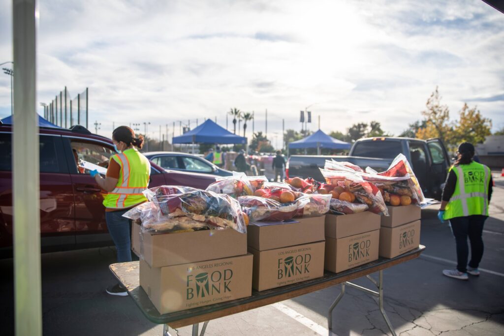 Food kits and fresh produce are stacked for distribution at a drive-through food giveaway hosted by the LA Regional Food Bank at Citrus College, CA.