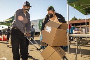 Food at a walk-up distribution being provided to older adult.