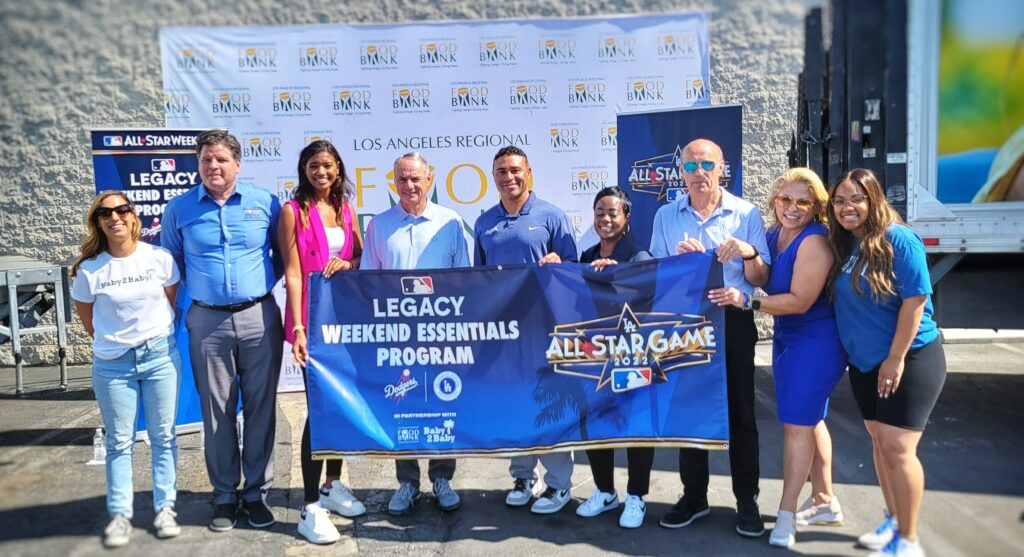 Stakeholders hold up a banner at the 2022 All-Star Legacy Initiative Event at the LA Regional Food Bank