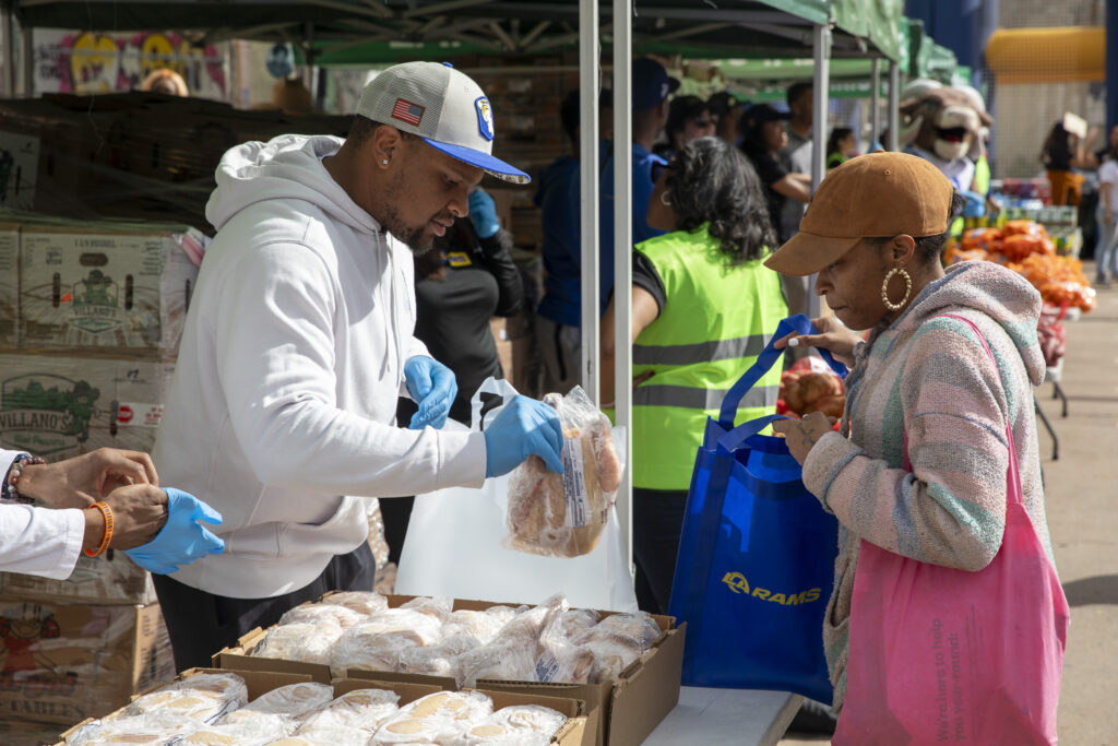 A volunteer offers a client chicken during a famer's market-style distribution in Leimert Park.