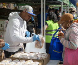 A volunteer offers a client chicken during a famer's market-style distribution in Leimert Park.