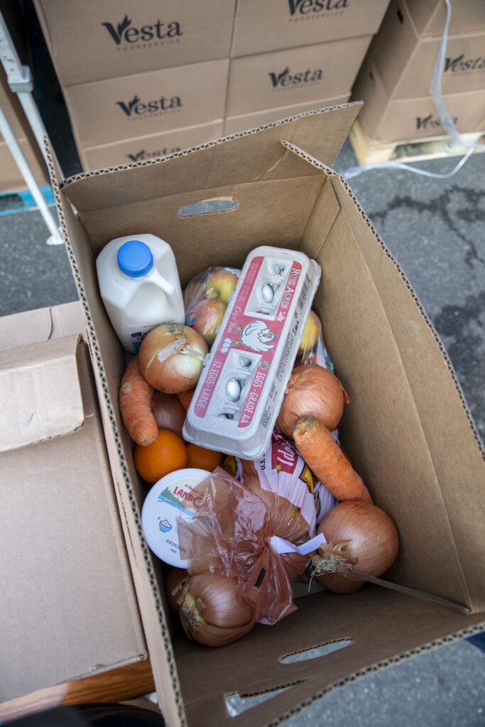 A typical Food Bank food box with fresh produce, milk and eggs.
