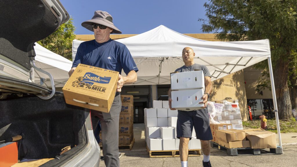 volunteers load at PazNaz load a vehicle with fresh produce and dairy