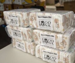 Six packs of size 4 diapers, each containing 20 diapers, are stacked on a table and labeled 
