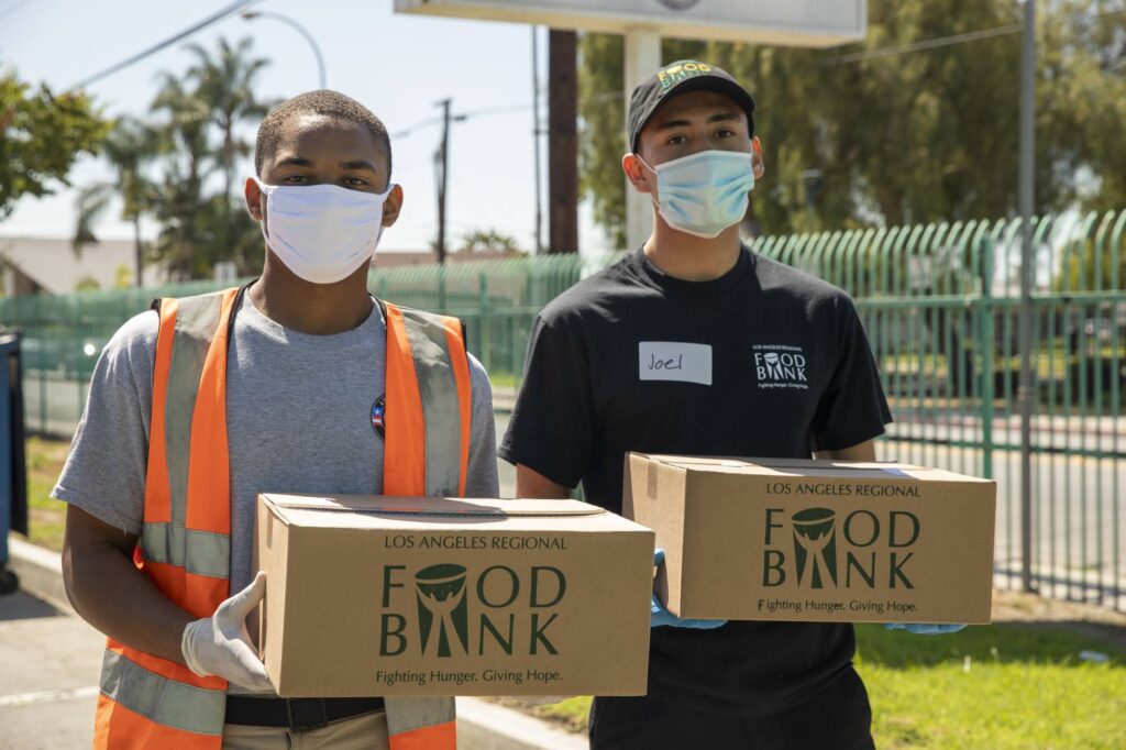 two volunteers hold Food Bank boxes
