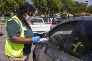A LA Regional Food Bank volunteer takes down information at a drive-through distribution.