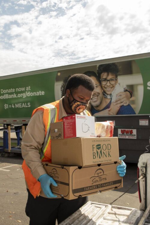 LA Regional Food Bank volunteer loads up a truck with food kits at a distribution.