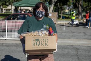 Volunteer Mary Connors holding a food box