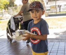 A small boy holds his lunch during a free summer meals distribution at Bristow Park during the 2023 summer
