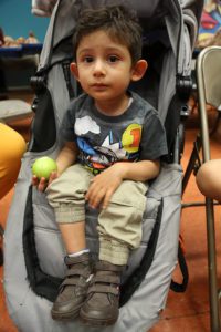 Young boy in stroller holding an apple.