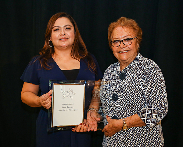 Elizabeth Cervantes (r) presents Elena Guzman with the Tony Collier Award at Season for Sharing Luncheon