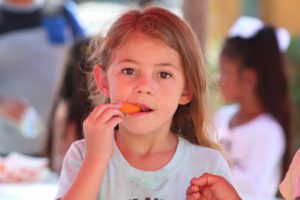 Young student eating a carrot