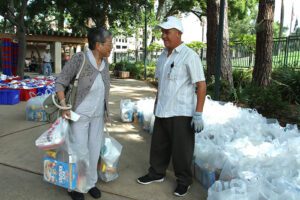 An elderly woman smiles as she receives food