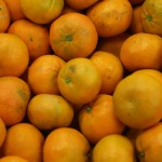 A pile of fresh oranges, with vibrant orange peels, closely stacked together, ready to bring a burst of citrus flavor to those in need at the Los Angeles Regional Food Bank.