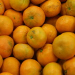 A pile of fresh oranges, with vibrant orange peels, closely stacked together, ready to bring a burst of citrus flavor to those in need at the Los Angeles Regional Food Bank.
