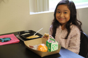 school girl enjoying summer lunch