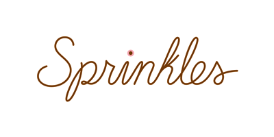 The image features the word "Sprinkles" in elegant, cursive brown script, with a small pink dot above the 'i.' This charming design could sweeten any event, even those supporting causes like the Los Angeles Regional Food Bank. The background is plain white.