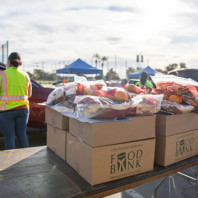 Boxes of food kits line up at a drive-through distribution.